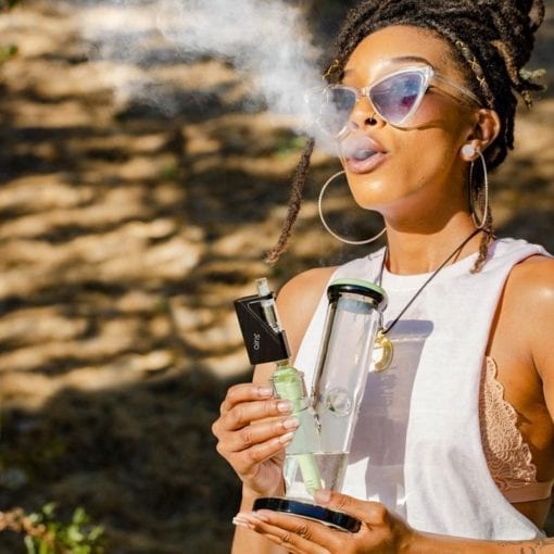 Photo of a woman using an Airis Dabble waterpipe attachment.